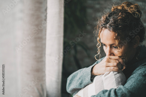 Foto Cheated wife suffering from breakout relationship hugging a pillow at home in front of the window light