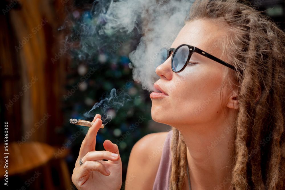 Fototapeta premium Hippie style woman smoking cigarettes with medical marijuana