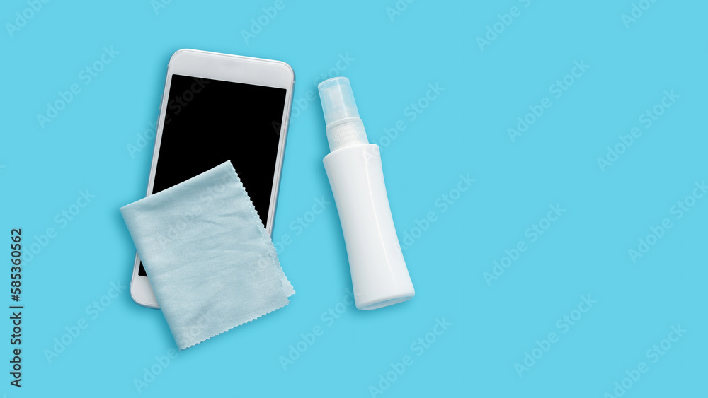 White smartphone and alcohol spray on a blue background. White smartphone and alcohol spray on a blue background.