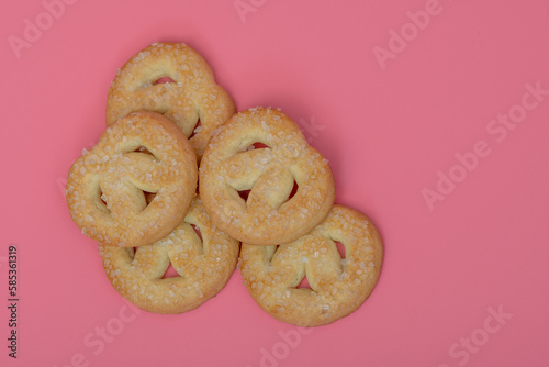Maślane ciasteczka posypane cukrem leżące na różowym stole