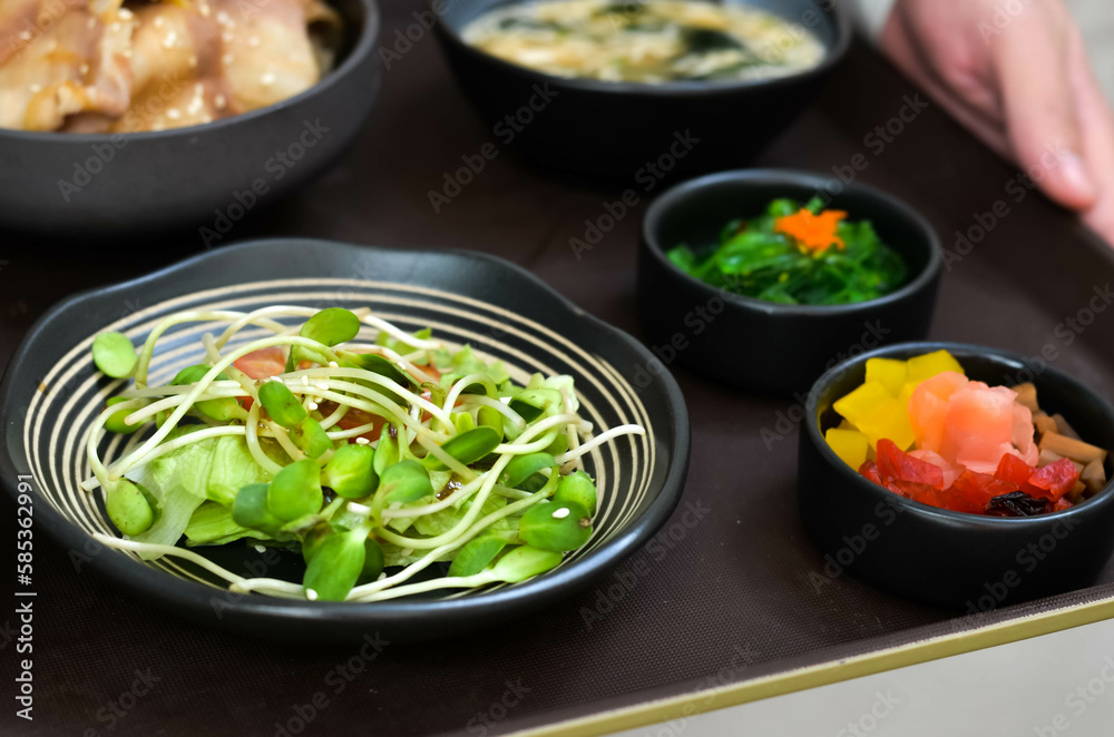 Grilled Pork Belly Sliced Rice with Fragrant Sauce Topped with Stir Fried Onions Served with salad and special soybean paste soup and Japanese side dishes. Grilled Pork Belly Sliced Rice with Fragrant Sauce Topped with Stir Fried Onions Served with salad and special soybean paste soup and Japanese side dishes.