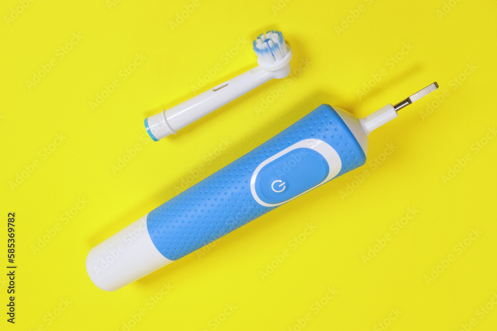 electric toothbrush and toothbrush head on yellow background, concept of oral hygiene, dental care electric toothbrush and toothbrush head on yellow background, concept of oral hygiene, dental care