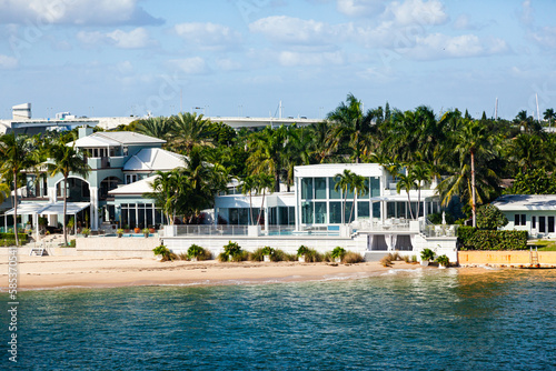 The coast of Florida in Fort Lauderdale, with luxurious private houses among palm trees on the ocean.