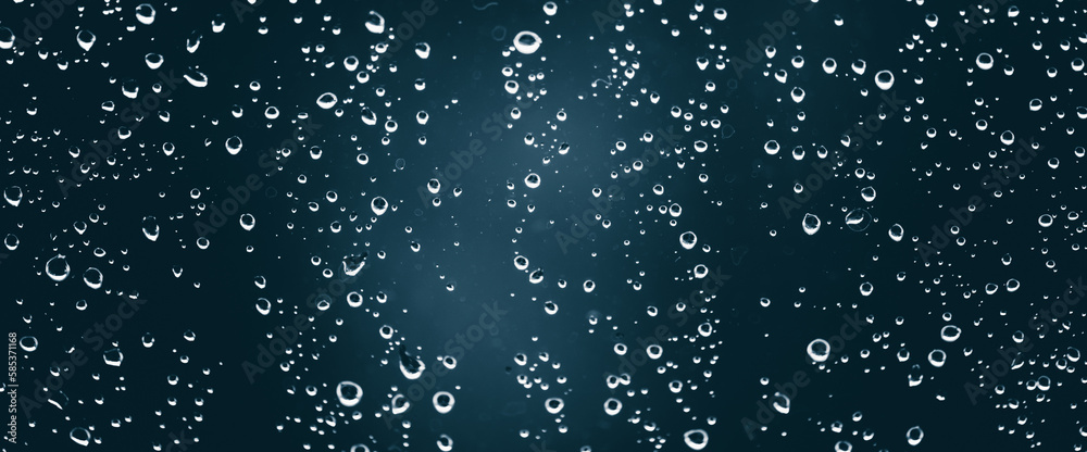 Fototapeta premium Atmospheric minimal monochrome backdrop with rain droplets on glass. Wet window with rainy drops and dirt spots closeup. Blurry minimalist background of dirty window glass with raindrops close up.