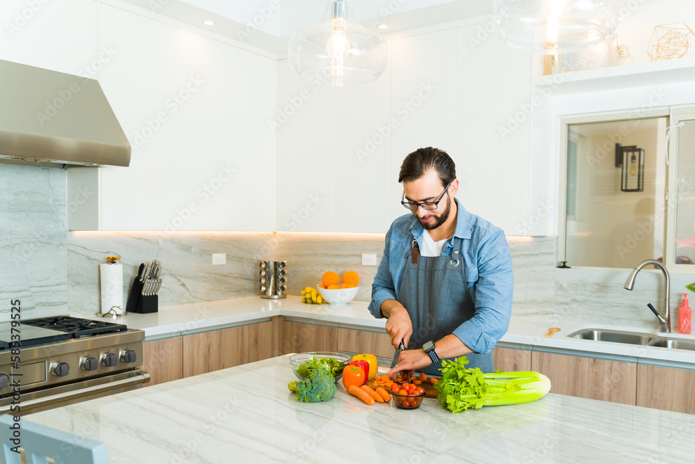 Happy man cooking healthy food in the luxury kitchen Happy man cooking healthy food in the luxury kitchen