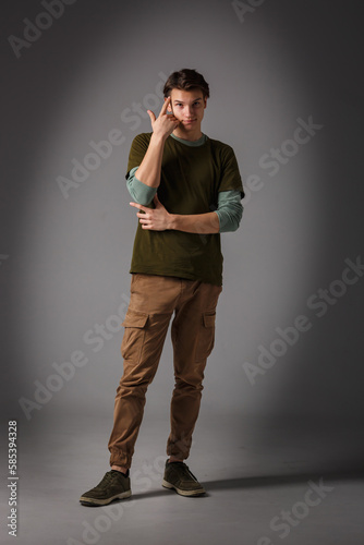 Fashion glamorous portrait of a handsome boy in on dark background in studio. © hiv360