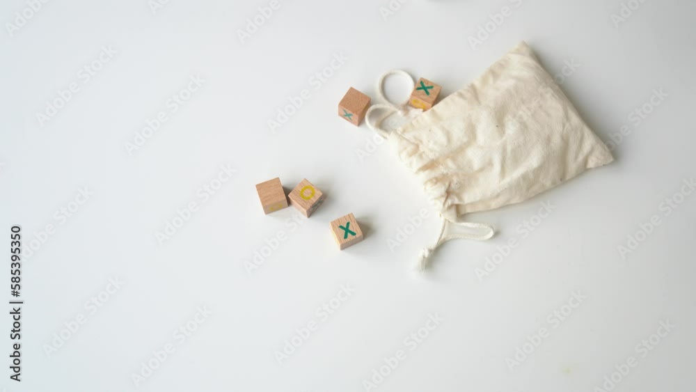 Wooden cubes fall on the white table. Tic Tac Toe on timbered cubes lie next to the pouch with laces. Business marketing strategy planning concept. Ligneous block tic tac toe board game on wood table Wooden cubes fall on the white table. Tic Tac Toe on timbered cubes lie next to the pouch with laces. Business marketing strategy planning concept. Ligneous block tic tac toe board game on wood table
