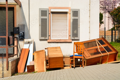 Foto Old wooden furnitures and bulky waste in front of a house.