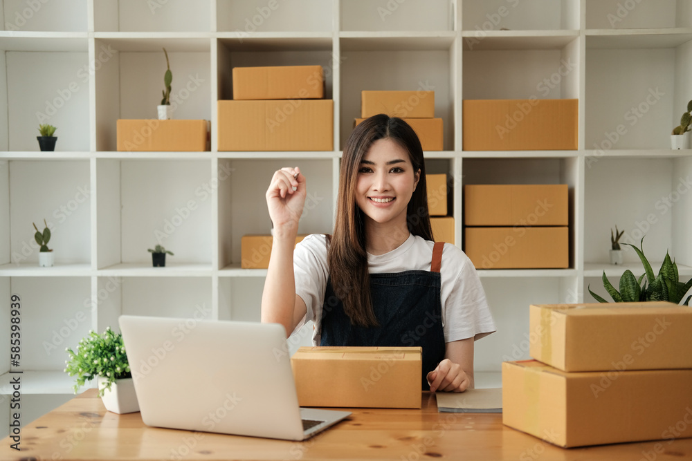 Start up successful small business owner,working from home with laptop computer and online purchase shopping order and box packaging on table (new normal concept) Start up successful small business owner,working from home with laptop computer and online purchase shopping order and box packaging on table (new normal concept)