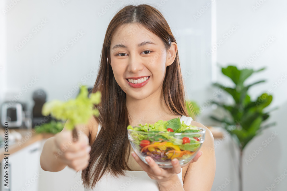 Diet, Dieting asian young woman or girl hand using fork at lettuce, green oak on mixed vegetables in salad bowl, eat food is low fat good health. Nutritionist female, Weight loss for healthy person. Diet, Dieting asian young woman or girl hand using fork at lettuce, green oak on mixed vegetables in salad bowl, eat food is low fat good health. Nutritionist female, Weight loss for healthy person.