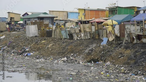 A slum with Polluted, filthy and dirty river water body in the biggest electronic waste dumpsite in the world. photo