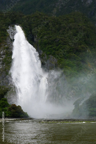 Turbulent waterfall falling from a mountain and striking the peaceful water with wonderful spray © Dominic DW
