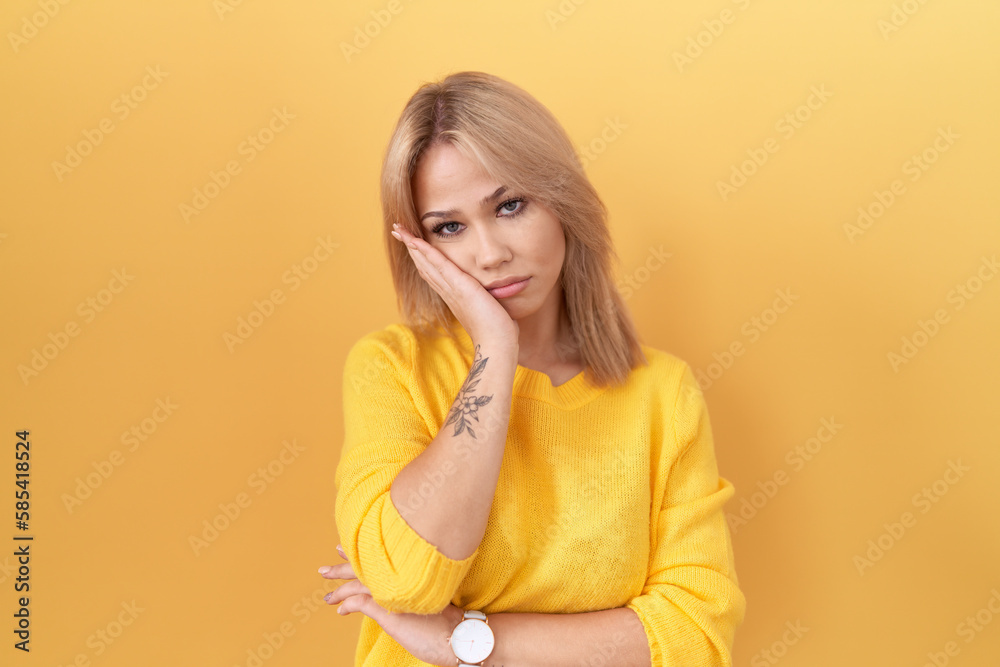 Young caucasian woman wearing yellow sweater thinking looking tired and bored with depression problems with crossed arms. Young caucasian woman wearing yellow sweater thinking looking tired and bored with depression problems with crossed arms.