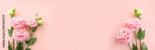Top view image of delicate pink flowers over pastel background photo