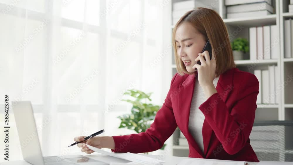 Young businesswomen in red suit working and talking with happy and smile face on a phone calling to client and colleague in office space. Young businesswomen in red suit working and talking with happy and smile face on a phone calling to client and colleague in office space.