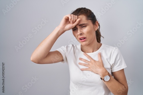 Beautiful brunette woman standing over isolated background touching forehead for illness and fever, flu and cold, virus sick