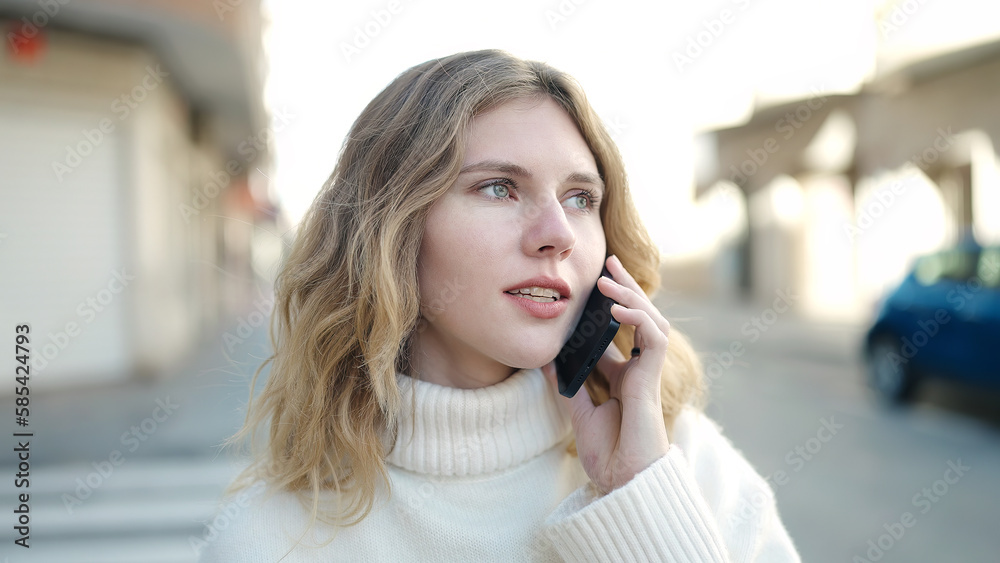 Young blonde woman talking on the smartphone with relaxed expression at street Young blonde woman talking on the smartphone with relaxed expression at street