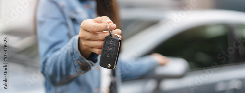 transportation rental automotive business concept. Close up hands of rental auto agent giving car remote key to client to travel sightseeing.