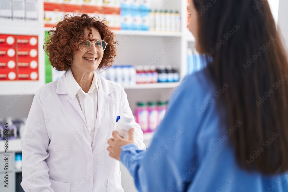 Two women pharmacist and customer prescribe pills at pharmacy Two women pharmacist and customer prescribe pills at pharmacy
