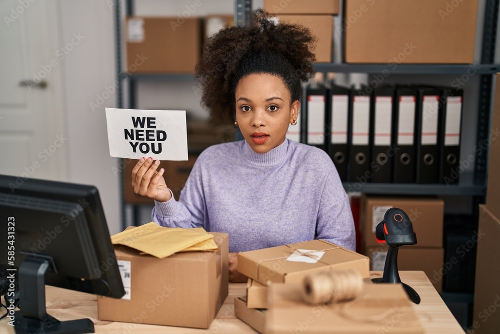 Young african american woman working at small business ecommerce holding banner scared and amazed with open mouth for surprise, disbelief face Young african american woman working at small business ecommerce holding banner scared and amazed with open mouth for surprise, disbelief face