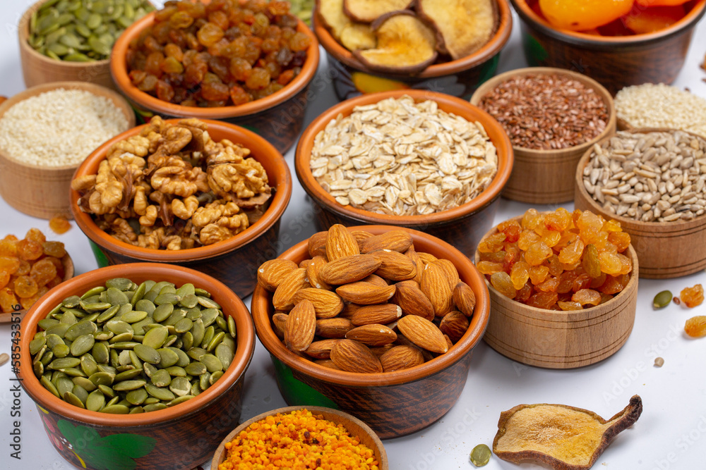 Healthy vegetarian food concept. Assortment of dried fruits, nuts and seeds on white background. Top view. Mixed nuts set closeup. Healthy vegetarian food concept. Assortment of dried fruits, nuts and seeds on white background. Top view. Mixed nuts set closeup.