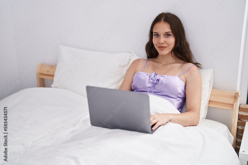 Young woman using laptop sitting on bed at bedroom Young woman using laptop sitting on bed at bedroom