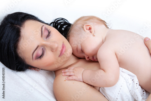 baby as leep on hands of mother on a light background photo