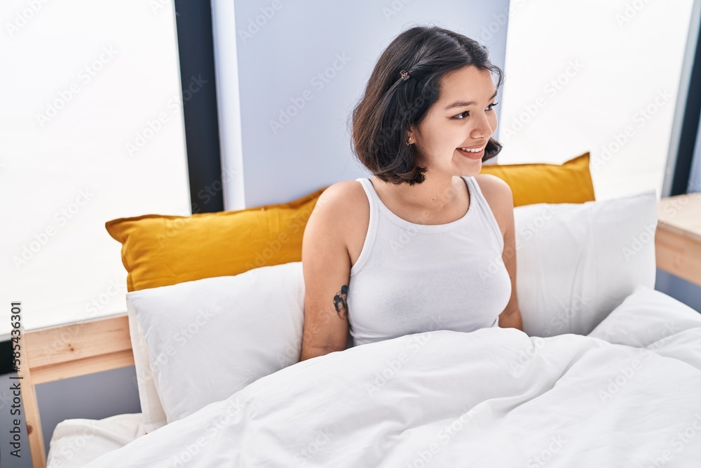 Young woman smiling confident sitting on bed at bedroom Young woman smiling confident sitting on bed at bedroom