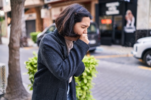 Young woman coughing at street