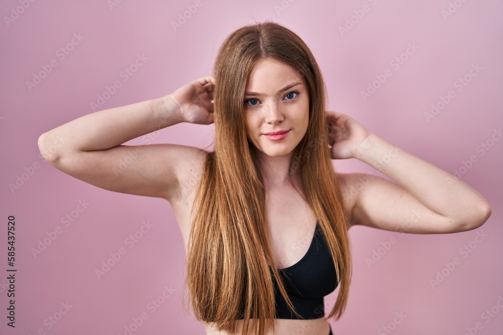 Young caucasian woman wearing lingerie over pink background relaxed with serious expression on face. simple and natural looking at the camera. Young caucasian woman wearing lingerie over pink background relaxed with serious expression on face. simple and natural looking at the camera.