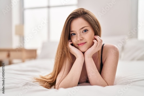 Young caucasian woman smiling confident lying on bed at bedroom