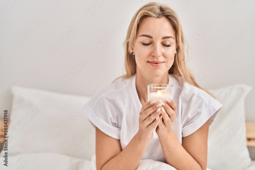 Young blonde woman drinking glass of water sitting on bed at bedroom Young blonde woman drinking glass of water sitting on bed at bedroom