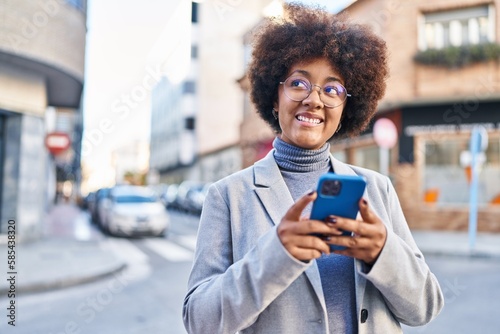 African american woman executive smiling confident using smartphone at street