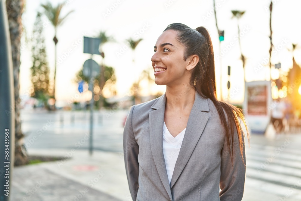 Young beautiful hispanic woman executive smiling confident looking to the side at street