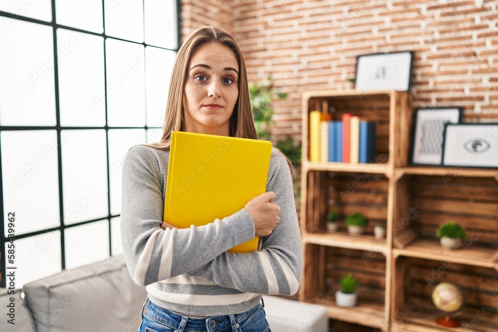 Young woman holding notebook skeptic and nervous, frowning upset because of problem. negative person. Young woman holding notebook skeptic and nervous, frowning upset because of problem. negative person.