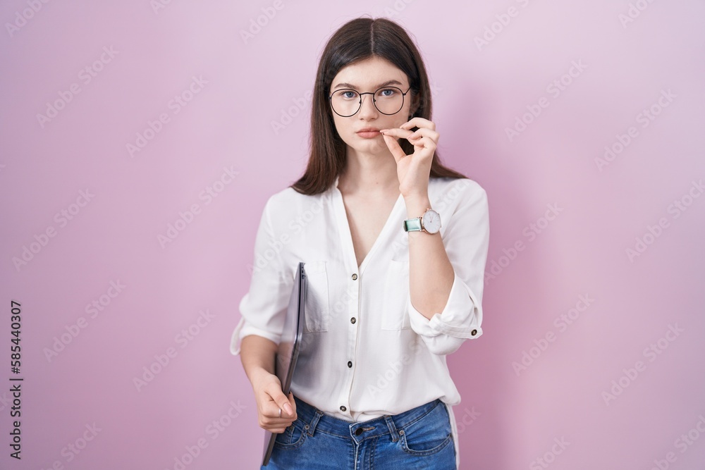 Young caucasian woman holding laptop mouth and lips shut as zip with fingers. secret and silent, taboo talking Young caucasian woman holding laptop mouth and lips shut as zip with fingers. secret and silent, taboo talking