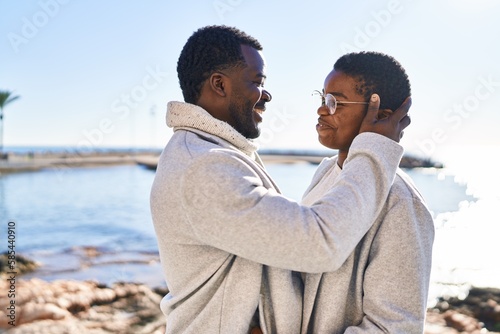 Man and woman couple hugging each other standing at seaside