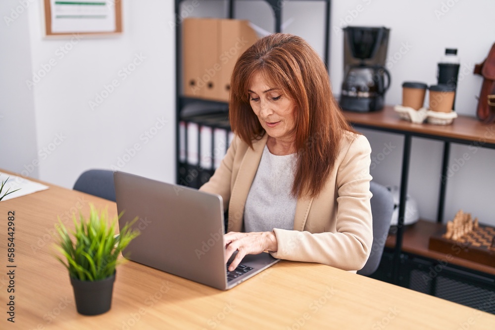 Middle age woman business worker using laptop working at office Middle age woman business worker using laptop working at office
