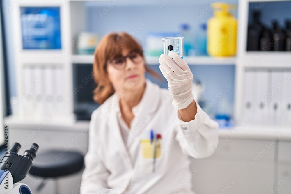 Middle age woman scientist looking sample at laboratory Middle age woman scientist looking sample at laboratory