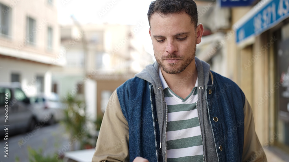 Young caucasian man using the phone with serious expression at street Young caucasian man using the phone with serious expression at street