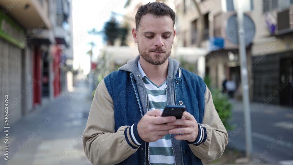 Young caucasian man using the phone with serious expression at street Young caucasian man using the phone with serious expression at street