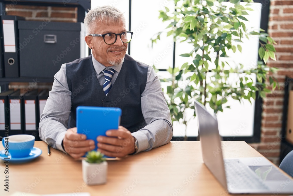 Middle age grey-haired man business worker using touchpad at office Middle age grey-haired man business worker using touchpad at office