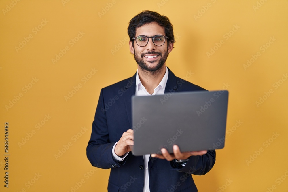 Handsome latin man working using computer laptop with a happy and cool smile on face. lucky person. Handsome latin man working using computer laptop with a happy and cool smile on face. lucky person.