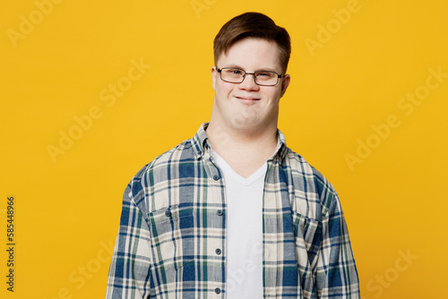 Fotografi Young smiling fun cheerful happy positive man with down syndrome wearing glasses blue casual clothes looking camera isolated on pastel plain yellow color background