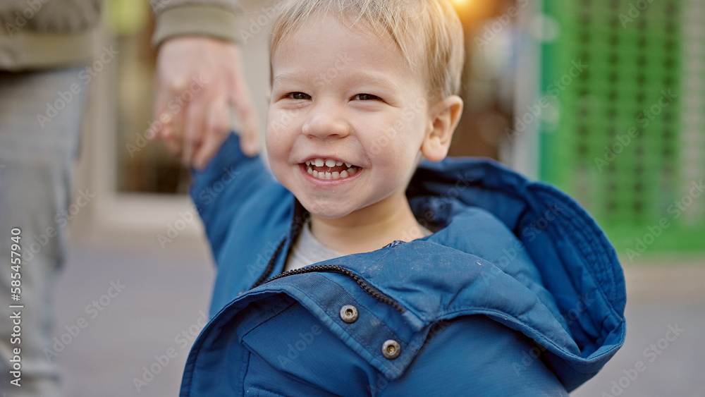 Caucasian toddler smiling cheerful holding hands with dad at street Caucasian toddler smiling cheerful holding hands with dad at street