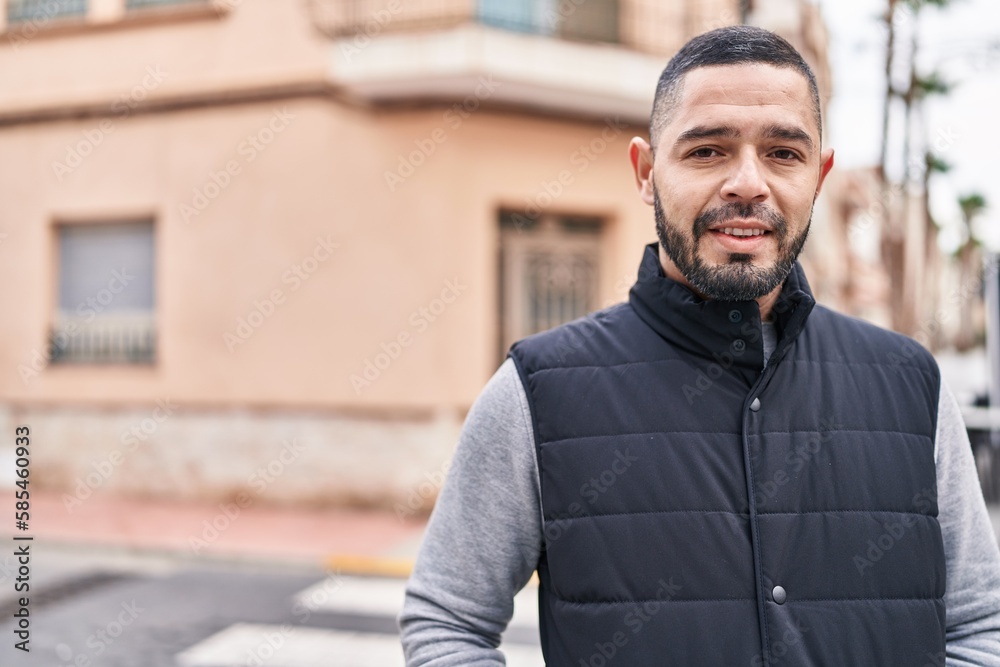 Naklejka premium Young latin man smiling confident standing at street