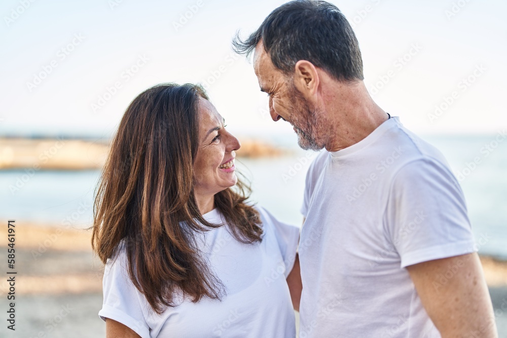 Middle age man and woman couple standing together at seaside