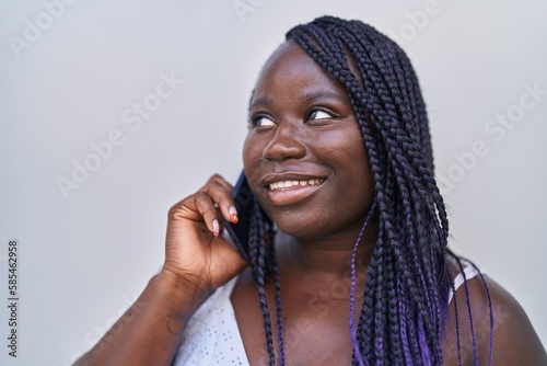 African american woman smiling confident talking on the smartphone over isolated white background