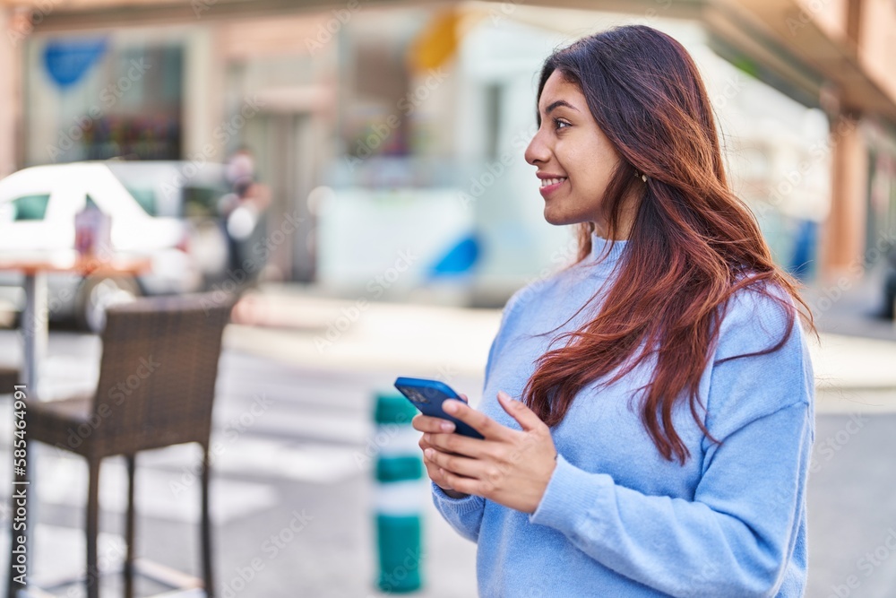 Young hispanic woman smiling confident using smartphone at street Young hispanic woman smiling confident using smartphone at street
