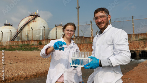 Male and female Biologist or natural science check drain water from factory ,Water environment pollution problem concept photo